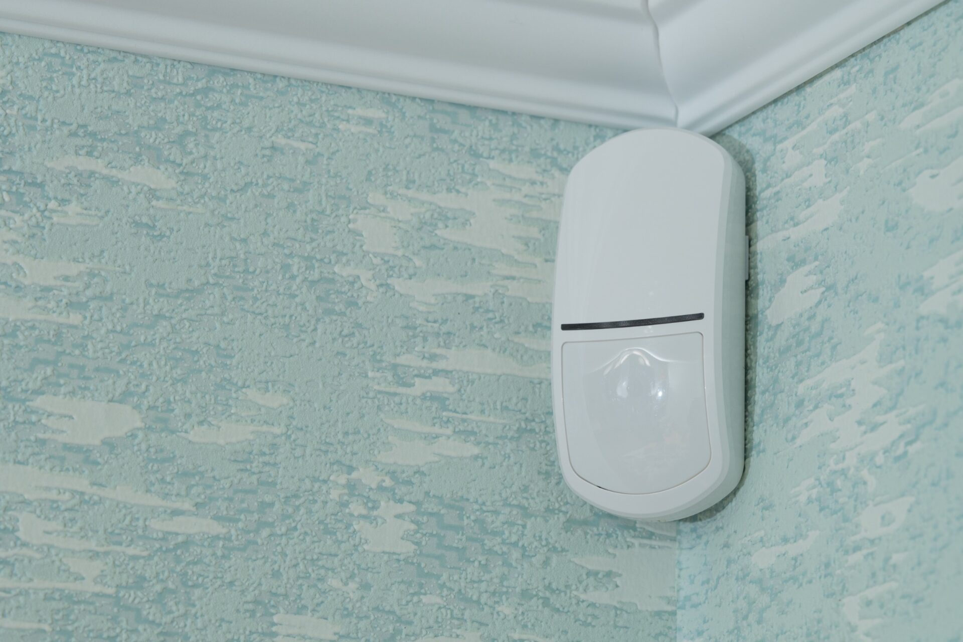 A motion sensor installed in the corner of a room.